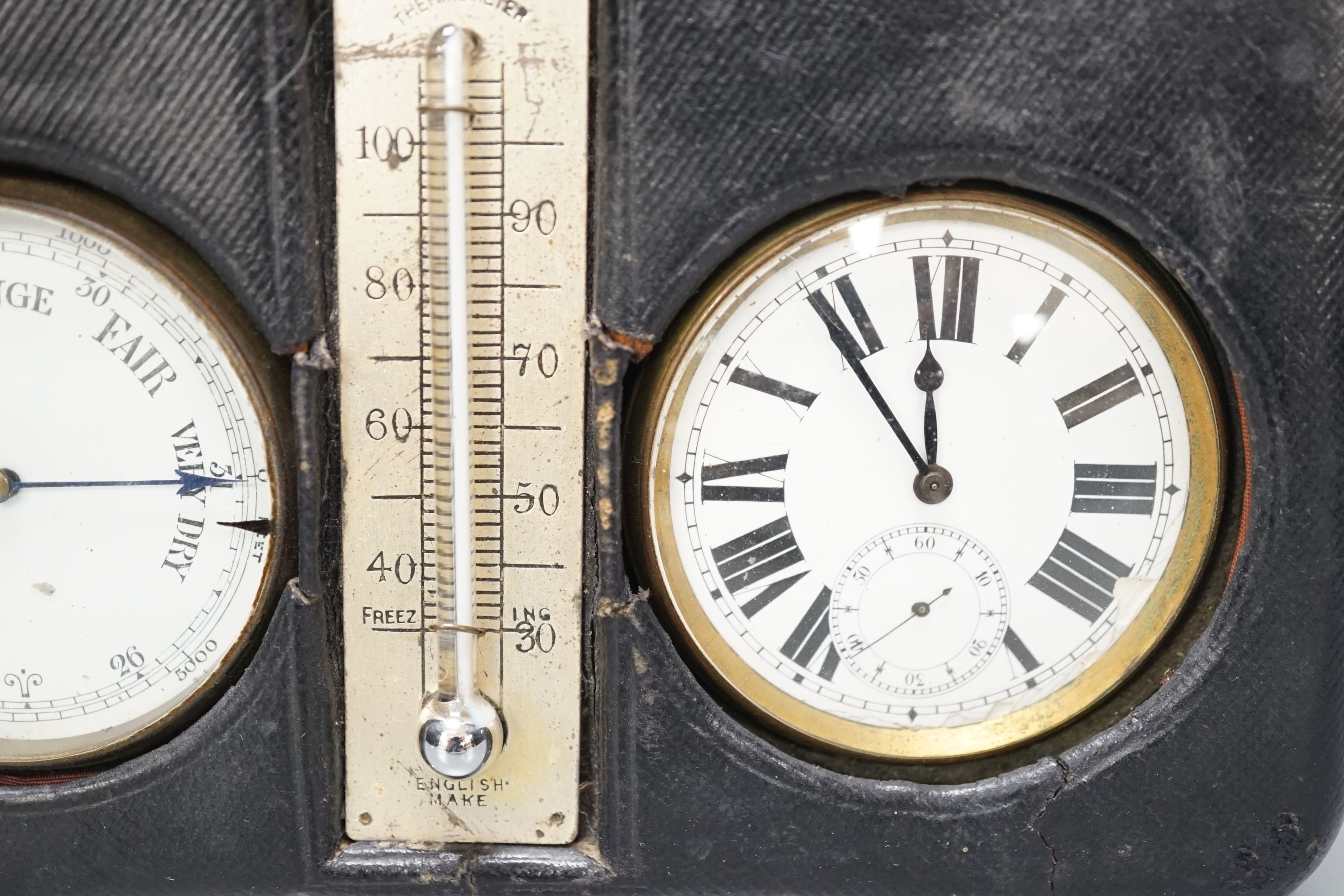 A leather cased pocket watch and barometer with central thermometer, 19.5 cm wide x 13 cms high.